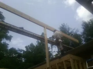 Carpenter setting a ridge beam over a new addition frame — Ice Dam Removal by Roofing Brothers in Harrison